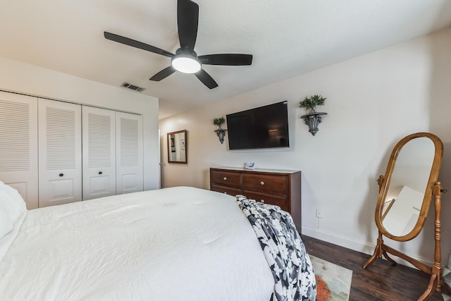 bedroom with dark wood-type flooring, ceiling fan, and a closet