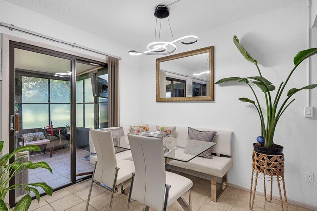 dining area with light tile patterned floors and an inviting chandelier