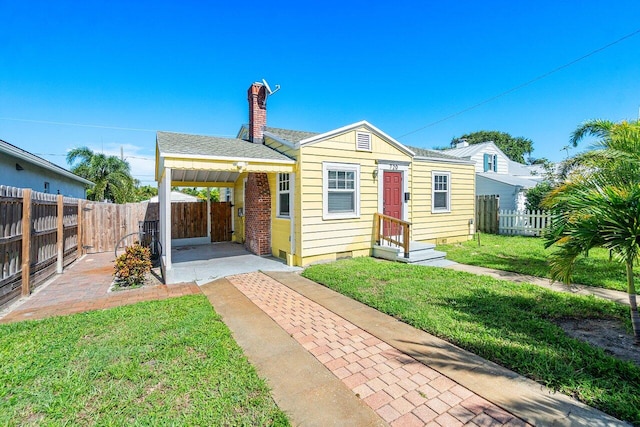 bungalow-style house with a front lawn and a patio