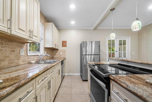 kitchen featuring appliances with stainless steel finishes, sink, light stone counters, and decorative backsplash