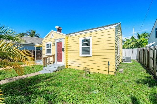 view of front of property with a front lawn and central AC unit