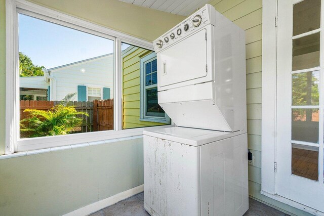 clothes washing area with stacked washer and dryer