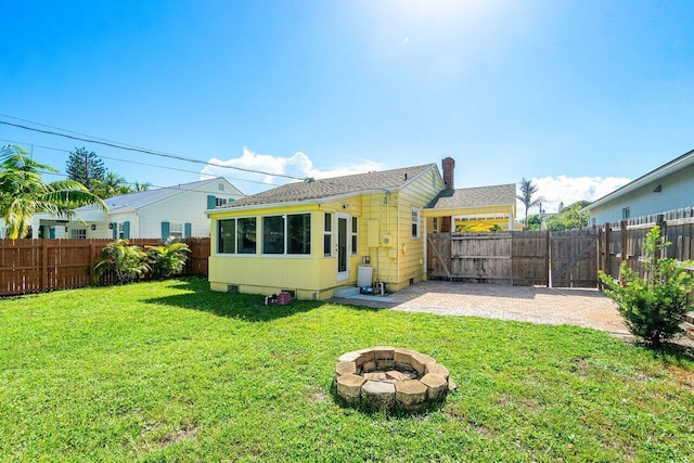 back of property featuring a patio, an outdoor fire pit, and a yard