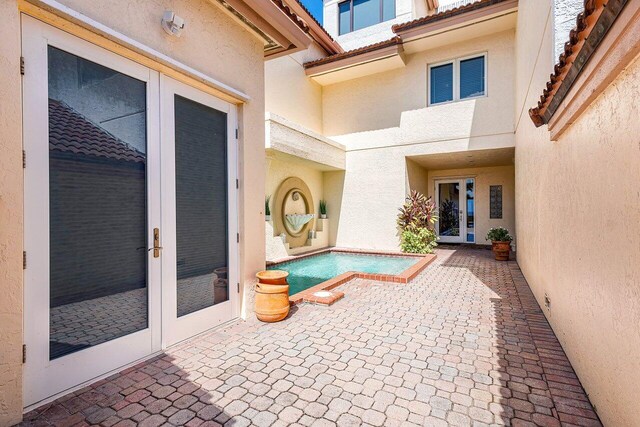 view of pool featuring a patio area and french doors