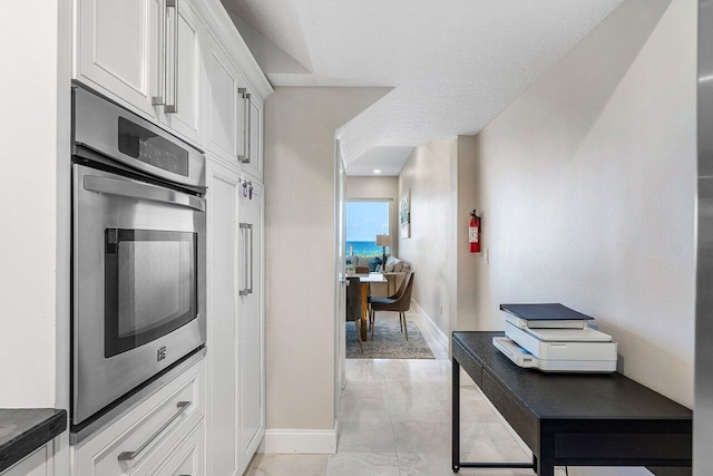 kitchen with white cabinetry and stainless steel oven