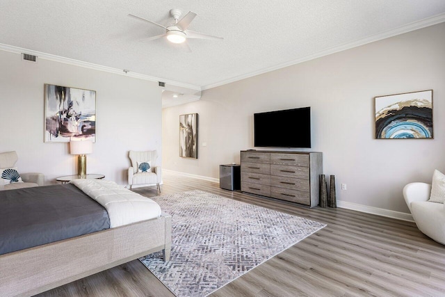 bedroom featuring ceiling fan, crown molding, wood-type flooring, and a textured ceiling