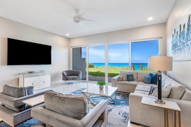 living room featuring ceiling fan and a water view