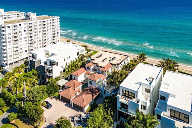 birds eye view of property with a water view and a beach view