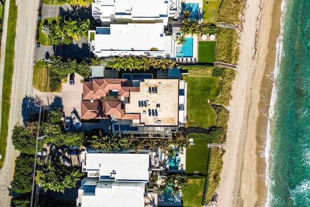 birds eye view of property featuring a water view and a beach view