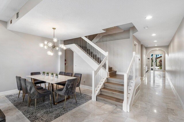 dining space featuring a textured ceiling and a chandelier