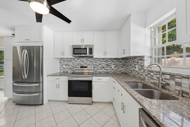 kitchen with dark stone countertops, sink, white cabinetry, and stainless steel appliances