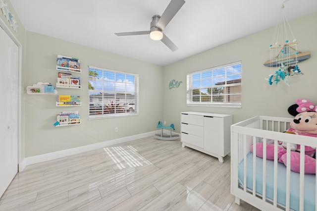 bedroom with ceiling fan, light hardwood / wood-style floors, and multiple windows