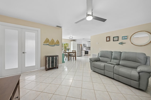 tiled living room with french doors and ceiling fan