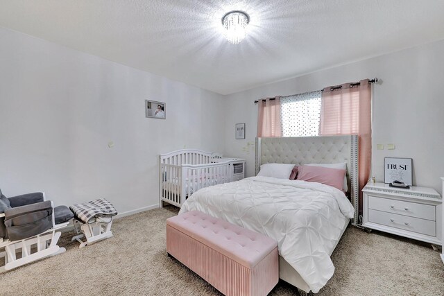 bedroom featuring a textured ceiling and light colored carpet