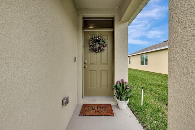 view of exterior entry featuring a yard