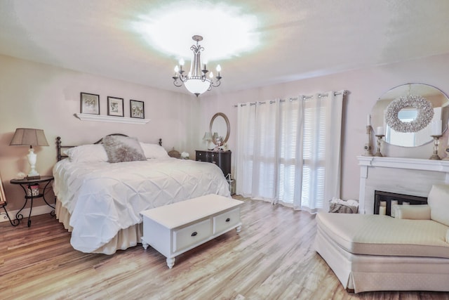 bedroom with light wood-type flooring and a notable chandelier