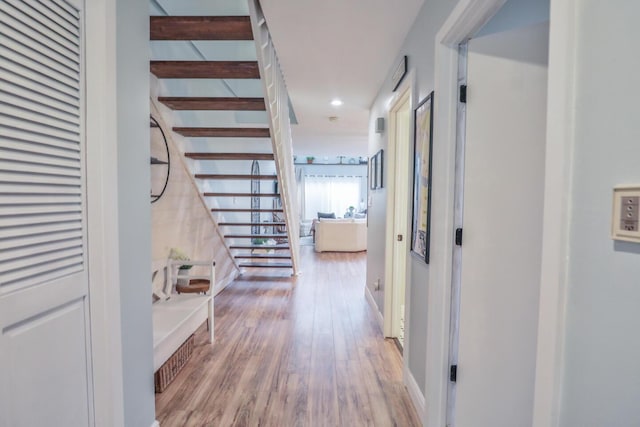 corridor featuring stairway, recessed lighting, wood finished floors, and baseboards