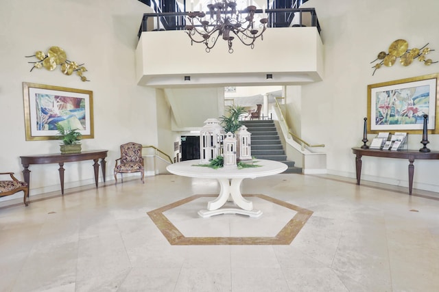 sitting room with a high ceiling, a notable chandelier, and tile patterned floors