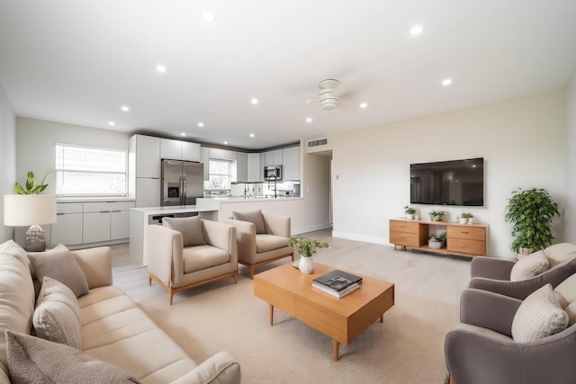 living room featuring ceiling fan and light carpet