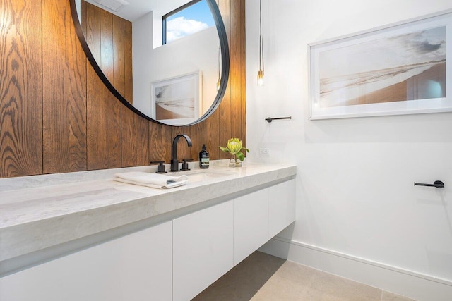 bathroom featuring vanity and wood walls