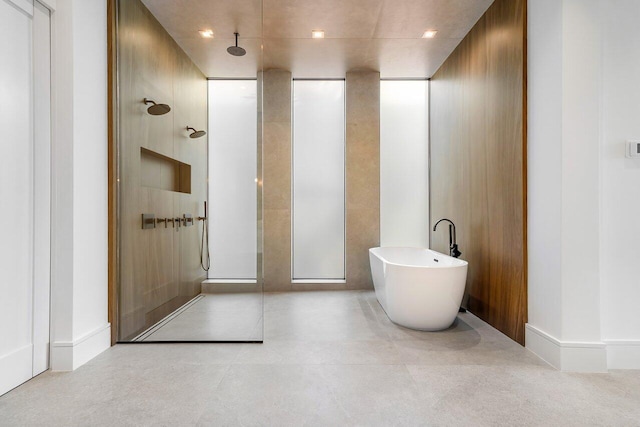 bathroom featuring tile patterned flooring, wooden walls, and shower with separate bathtub