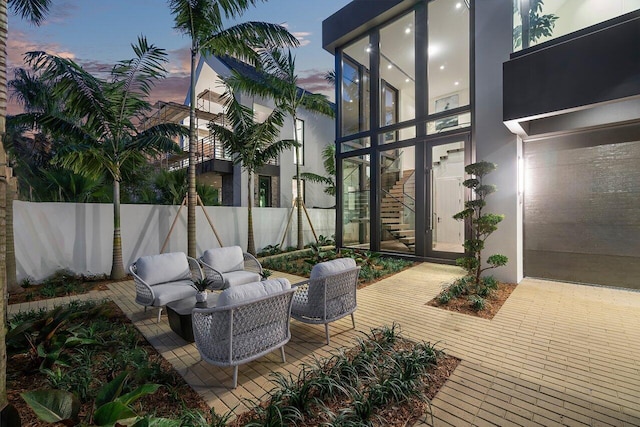 patio terrace at dusk featuring an outdoor living space