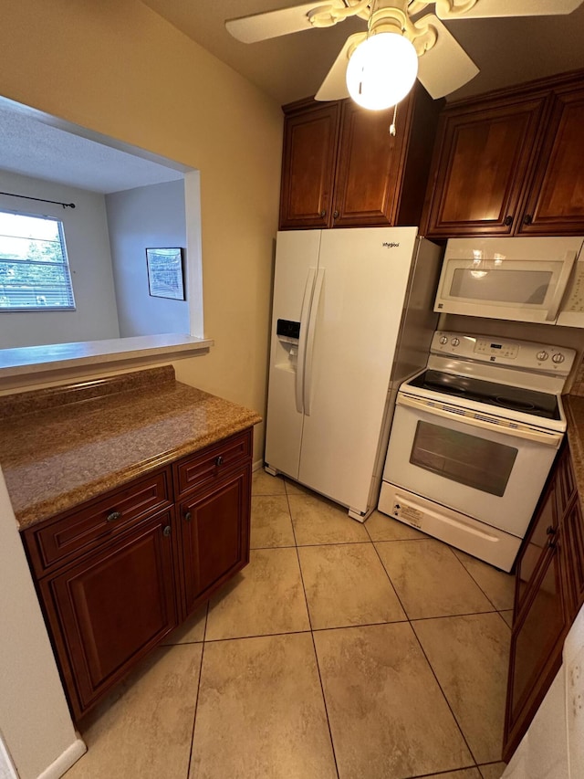 kitchen with light tile patterned floors, white appliances, and ceiling fan