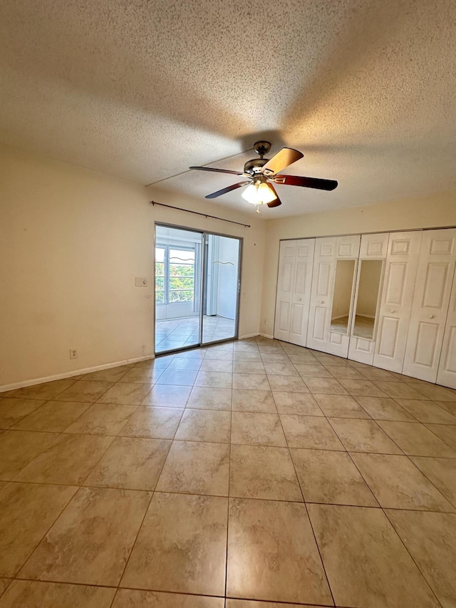 unfurnished bedroom featuring ceiling fan, a textured ceiling, and light tile patterned floors