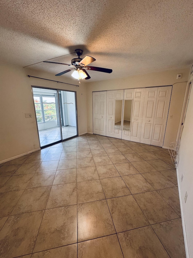 unfurnished bedroom with ceiling fan, light tile patterned flooring, a textured ceiling, and access to exterior