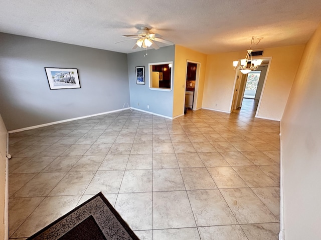 empty room with light tile patterned floors, a textured ceiling, ceiling fan with notable chandelier, visible vents, and baseboards