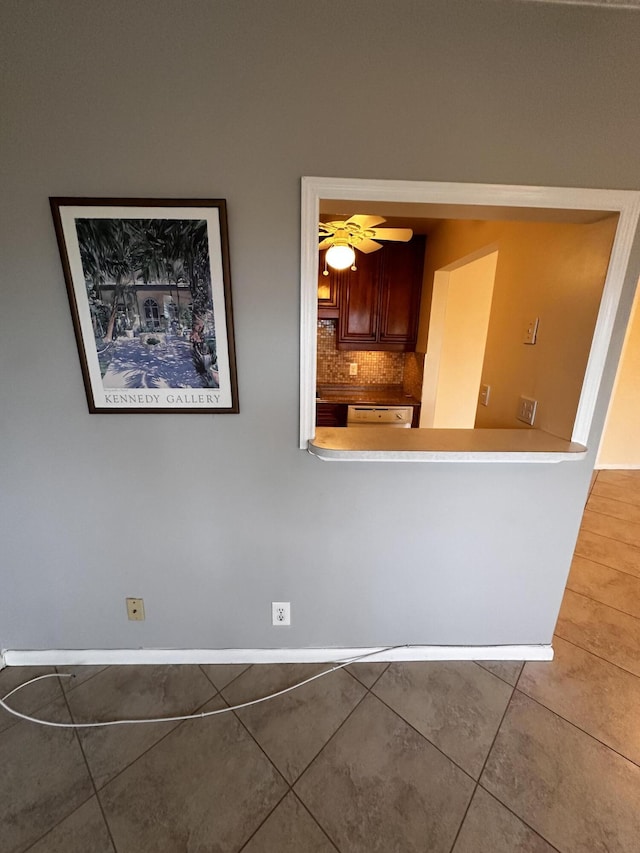 kitchen with baseboards, dishwasher, ceiling fan, tile patterned flooring, and backsplash