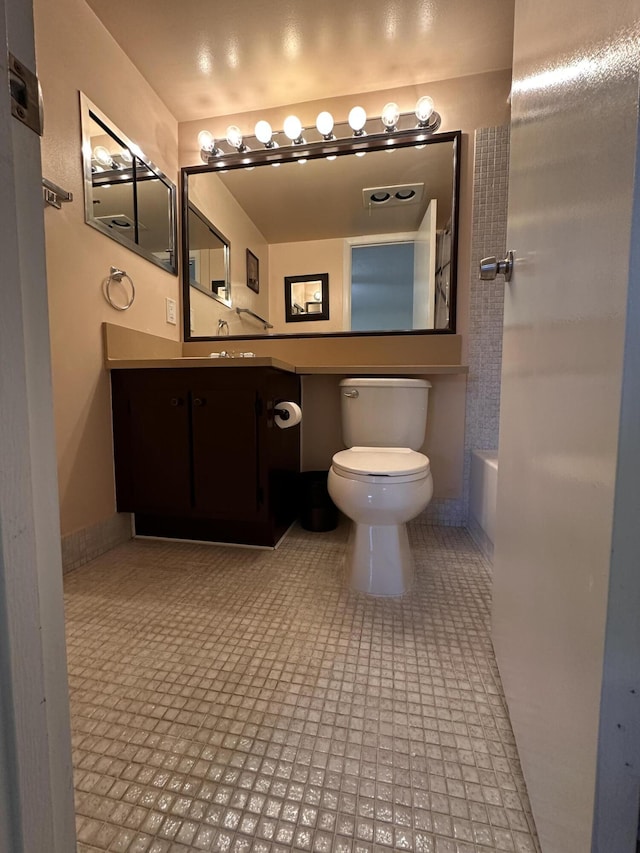 bathroom featuring vanity, toilet, and tile patterned flooring