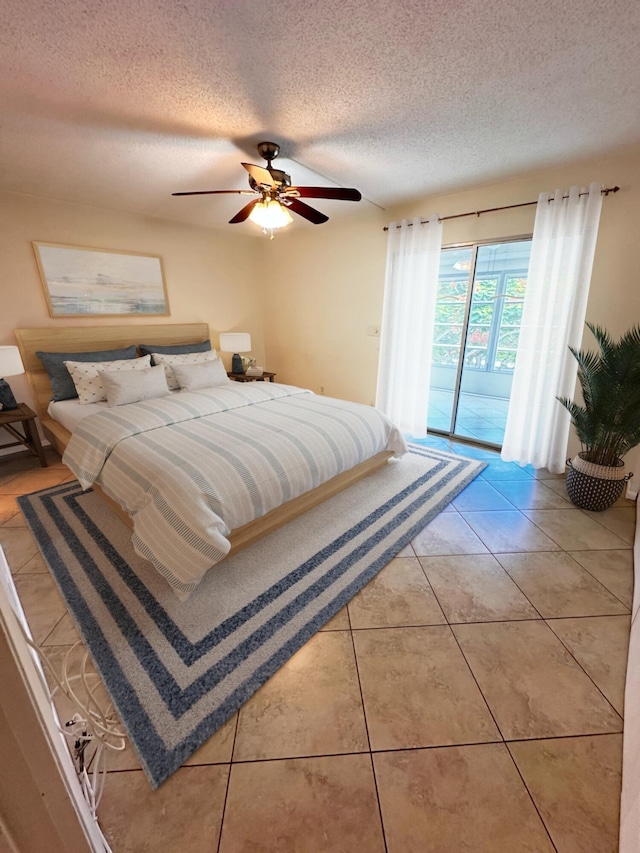 bedroom with a textured ceiling, access to outside, ceiling fan, and tile patterned floors