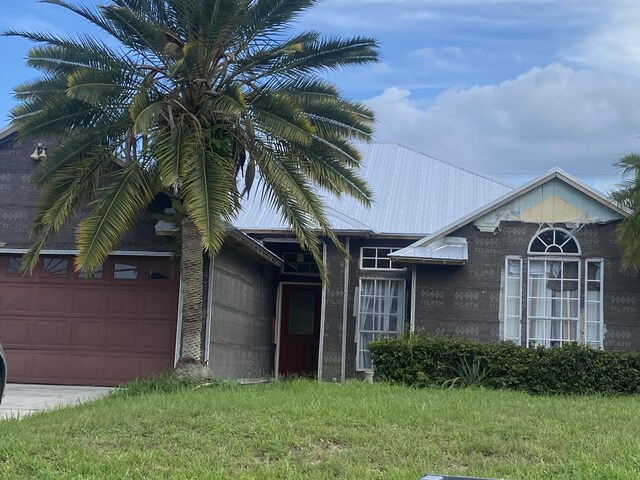 view of front of home featuring a front lawn and a garage