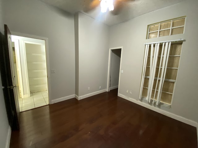 unfurnished room featuring dark wood-type flooring and ceiling fan