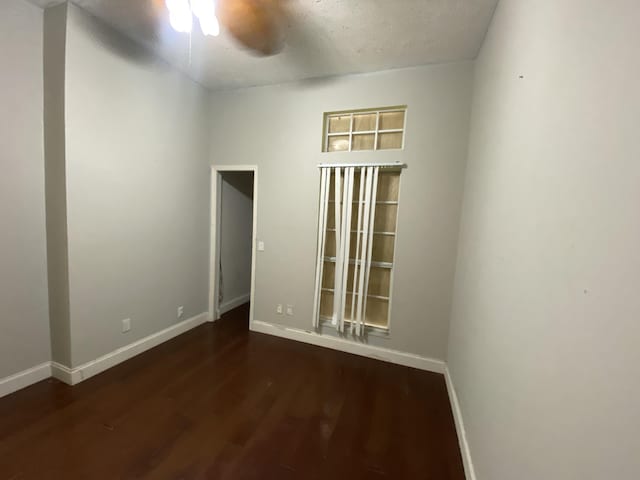 spare room featuring dark hardwood / wood-style floors, a textured ceiling, and ceiling fan