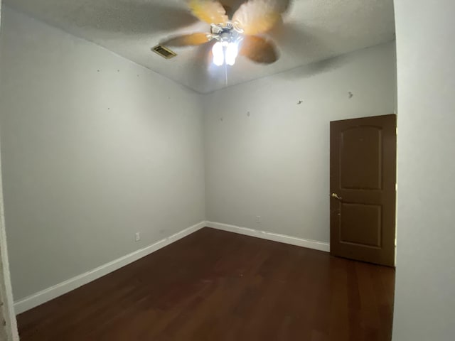 empty room featuring dark hardwood / wood-style flooring and ceiling fan