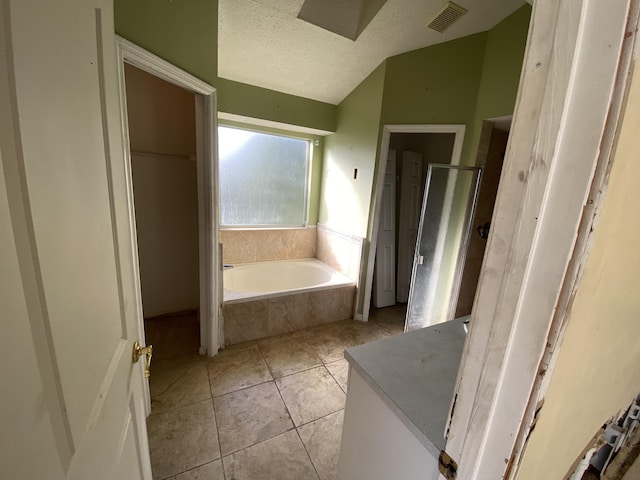 bathroom with lofted ceiling, a textured ceiling, vanity, independent shower and bath, and tile patterned flooring