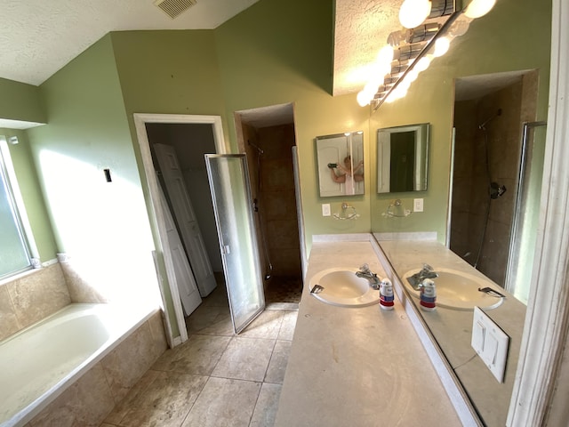 bathroom featuring separate shower and tub, tile patterned flooring, vanity, and a textured ceiling