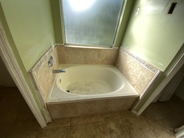 bathroom with a bathing tub and tile patterned flooring