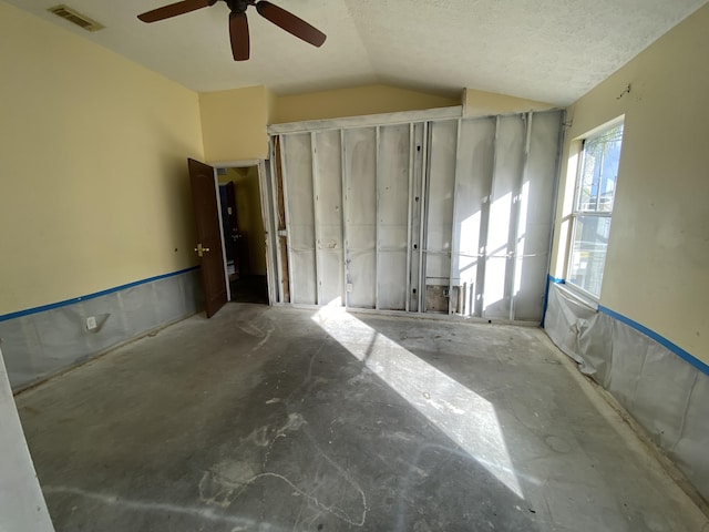 interior space with a textured ceiling, vaulted ceiling, and ceiling fan