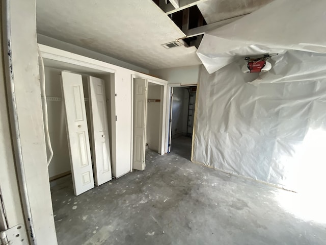 unfurnished bedroom featuring multiple closets and concrete floors