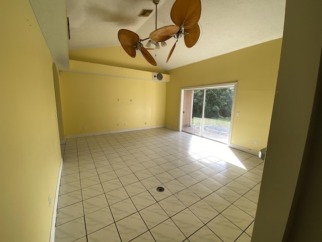 tiled empty room with vaulted ceiling and ceiling fan