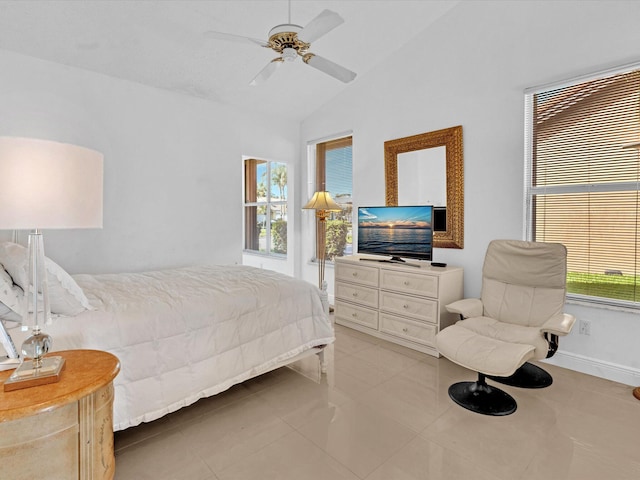 tiled bedroom featuring ceiling fan, vaulted ceiling, and multiple windows