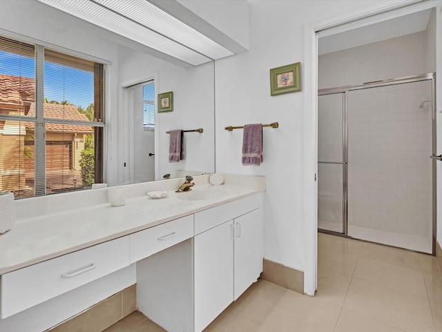 bathroom with a shower with door, tile patterned flooring, and vanity