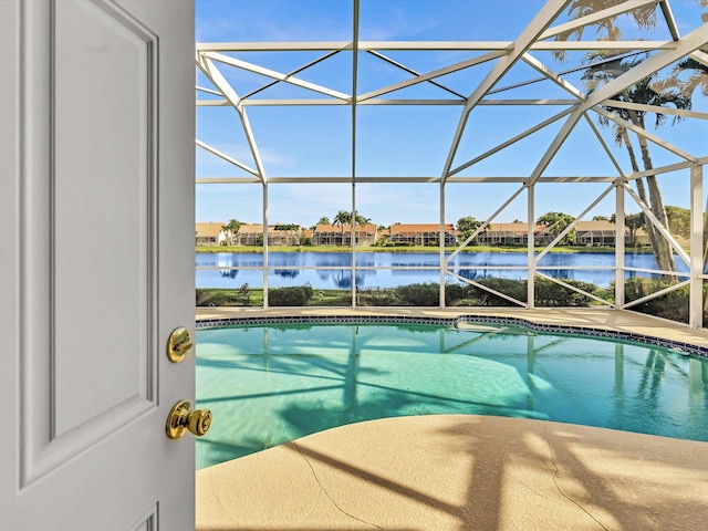 view of swimming pool with a lanai and a water view