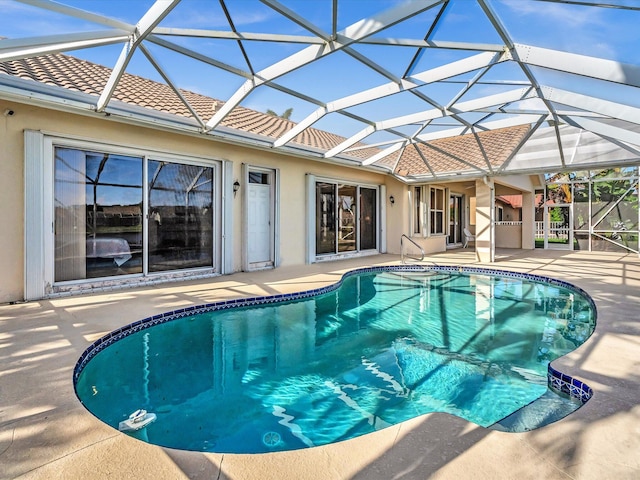 view of swimming pool with glass enclosure and a patio area