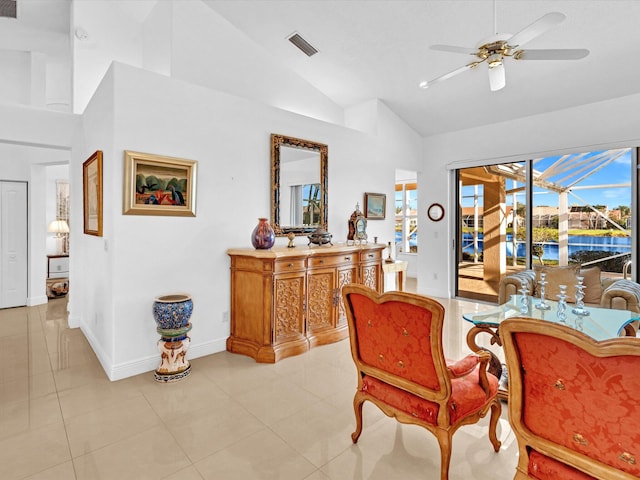 tiled dining space with ceiling fan and high vaulted ceiling