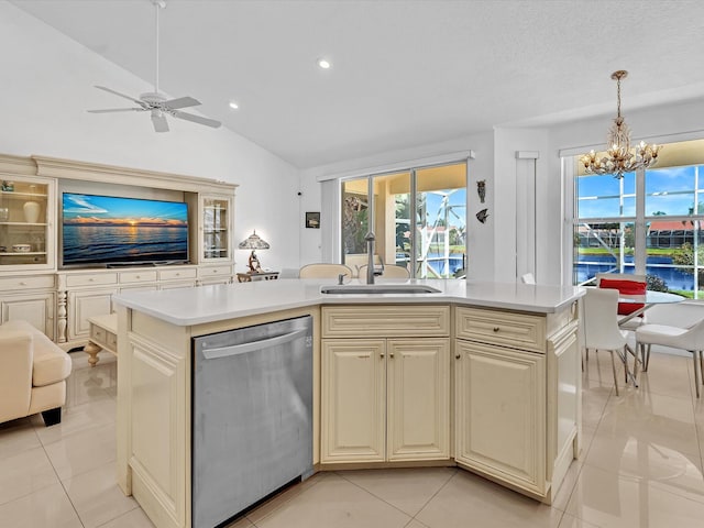 kitchen with light tile patterned floors, lofted ceiling, hanging light fixtures, and dishwasher