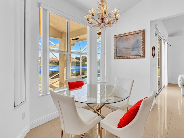 dining area featuring a water view, light tile patterned floors, and an inviting chandelier